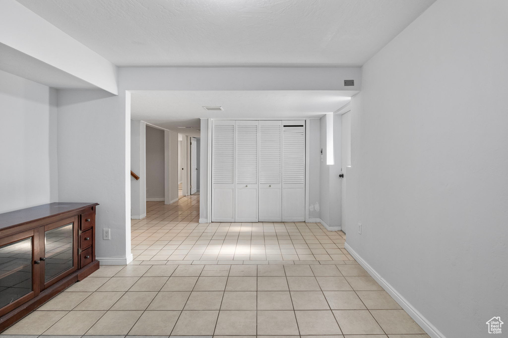 Spare room featuring light tile patterned floors and stairway