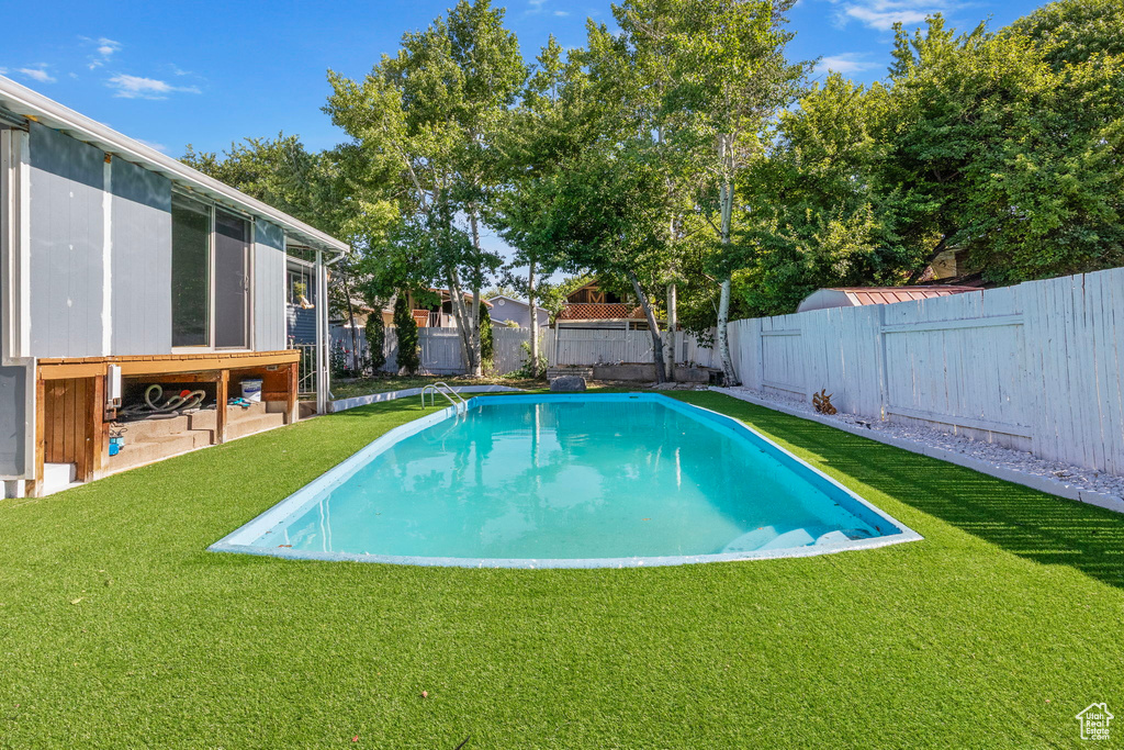 View of swimming pool with a fenced backyard and a sunroom