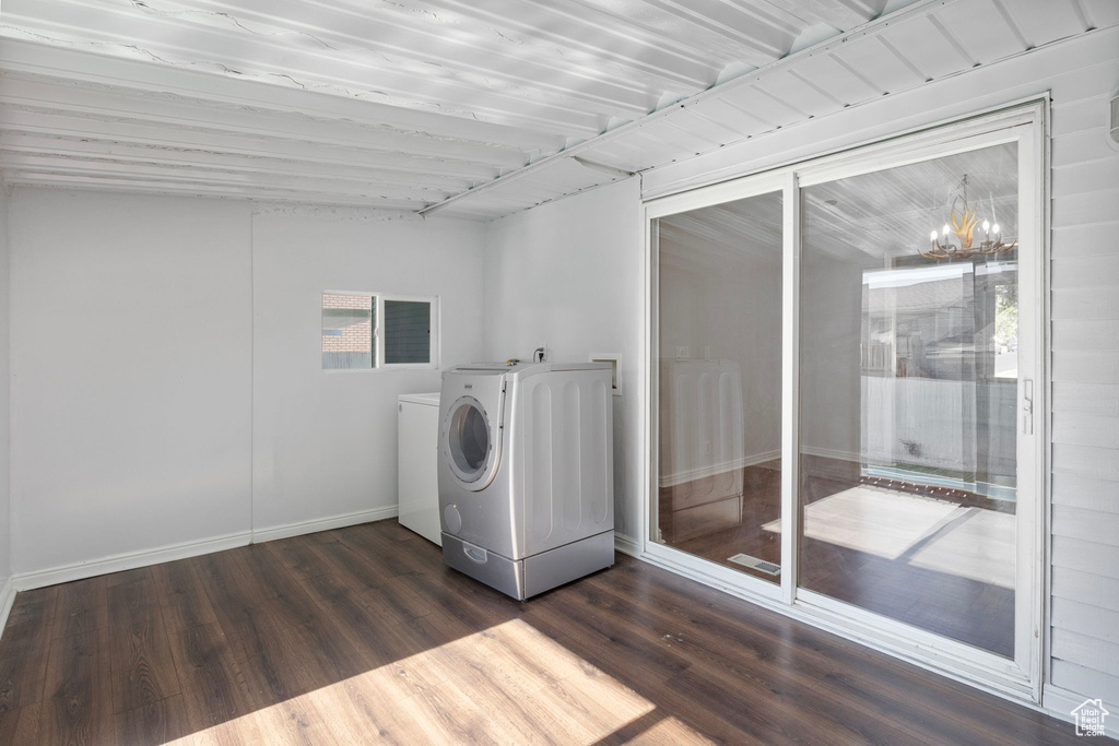 Laundry room featuring washer and dryer, dark wood finished floors, and a chandelier