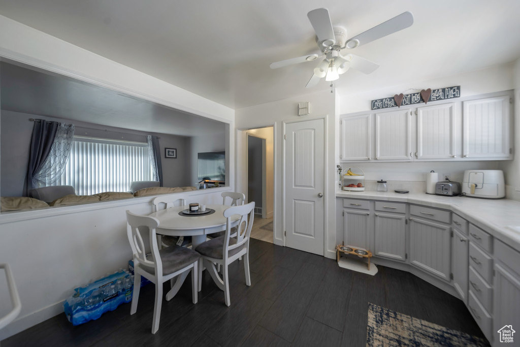 Dining area featuring ceiling fan and dark wood-style floors