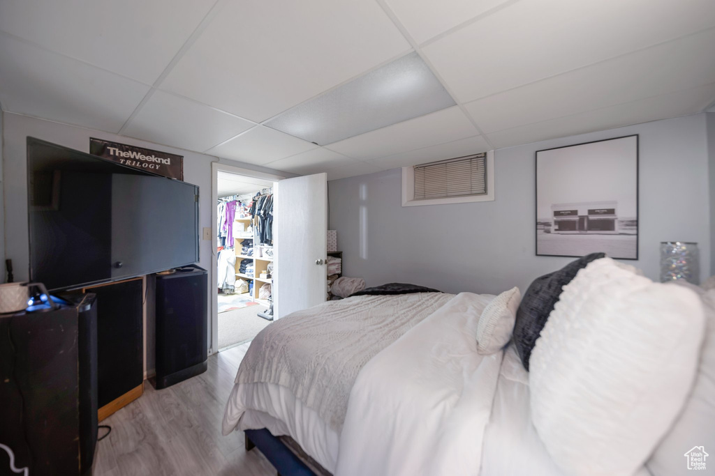 Bedroom with wood finished floors and a paneled ceiling