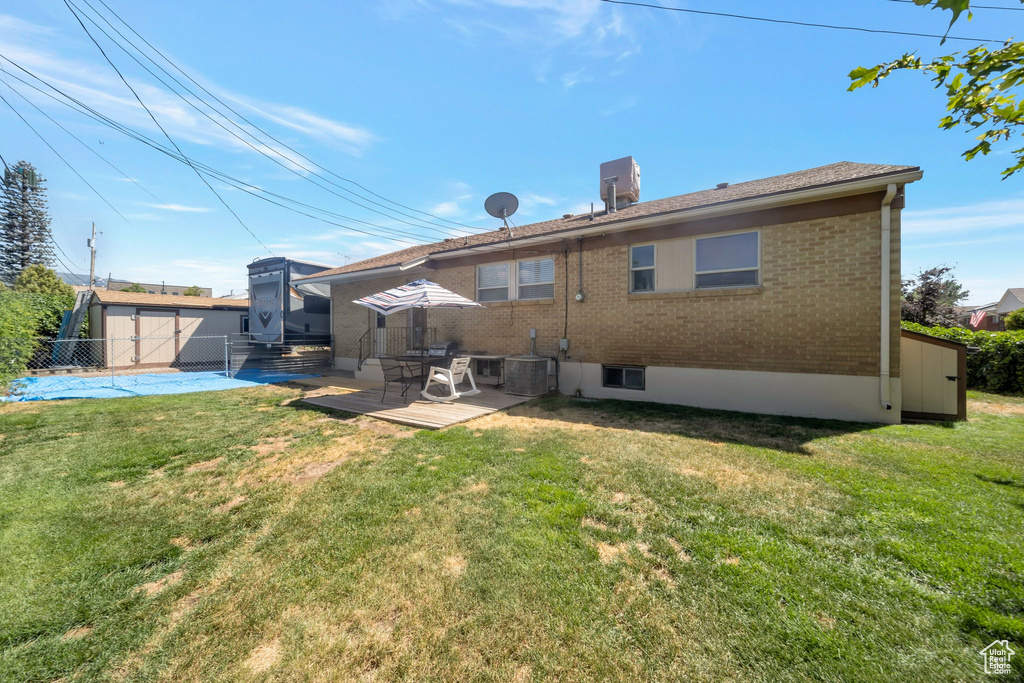 Rear view of house with brick siding, a patio, and a storage shed