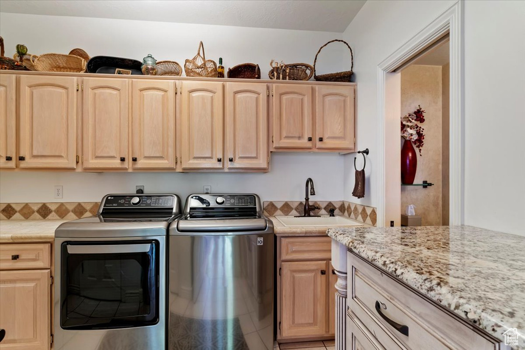 Laundry room featuring cabinet space, separate washer and dryer, and light tile patterned floors