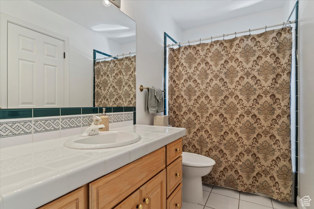 Bathroom with vanity, tile patterned floors, and curtained shower