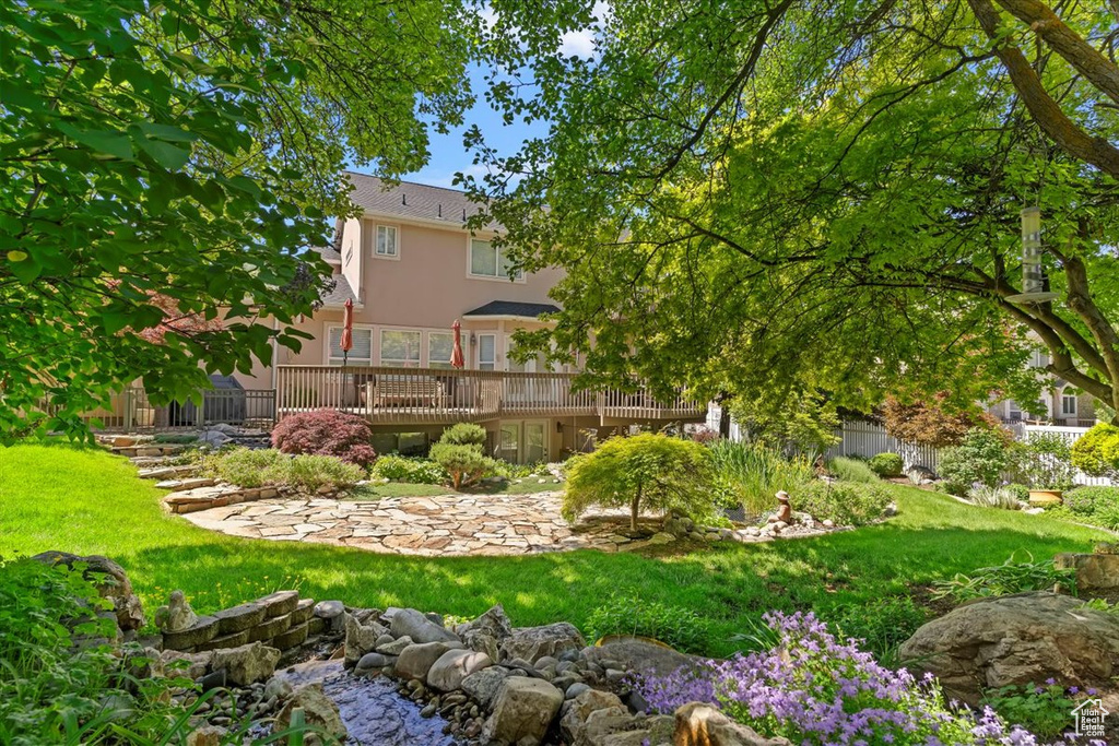 View of green lawn featuring a deck