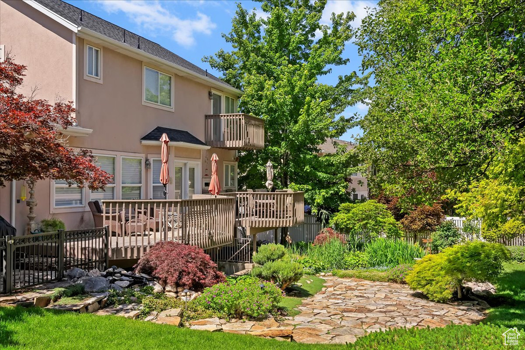 Rear view of property with stucco siding and a balcony