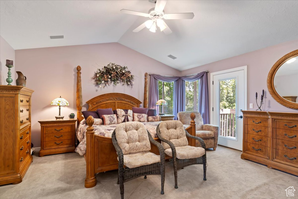 Bedroom with access to exterior, light colored carpet, vaulted ceiling, and a ceiling fan