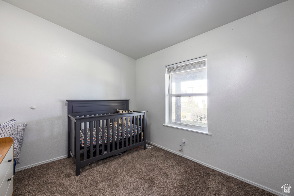 Carpeted bedroom featuring baseboards and vaulted ceiling