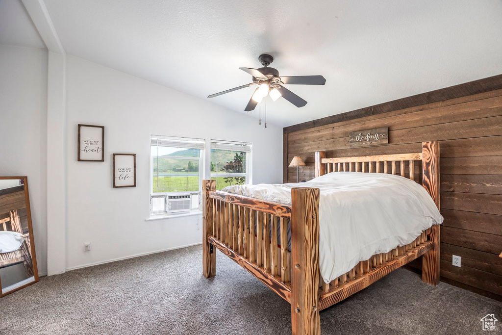 Carpeted bedroom with cooling unit, a ceiling fan, and vaulted ceiling