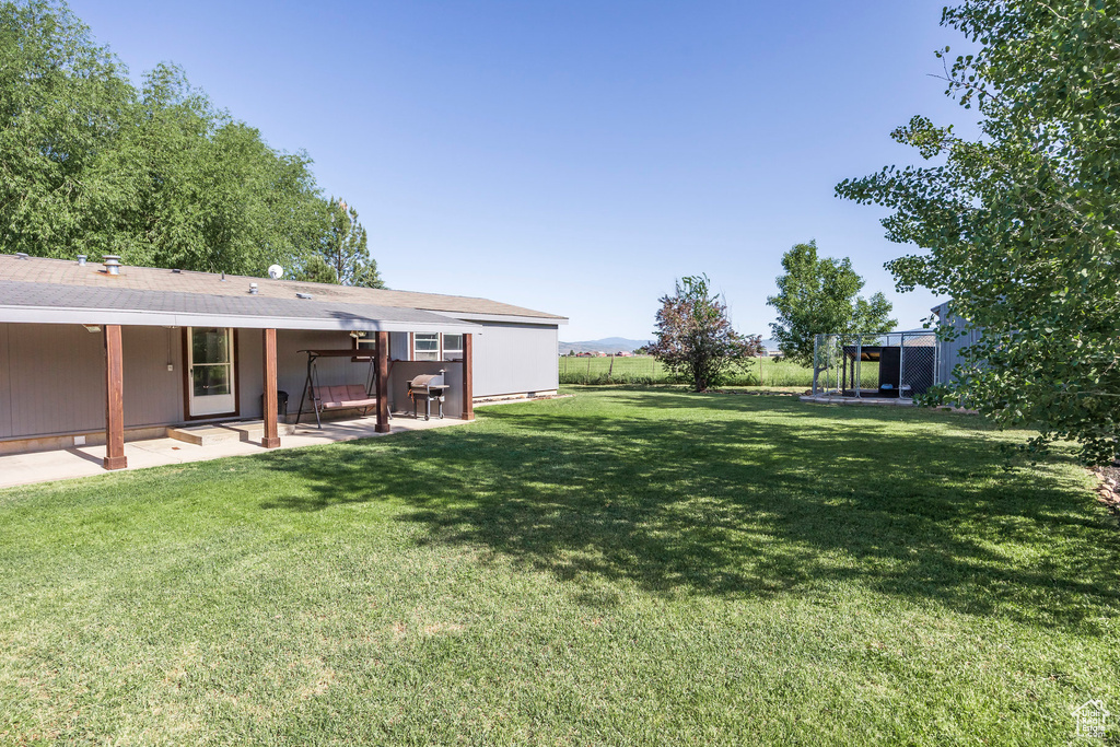 View of green lawn featuring a patio