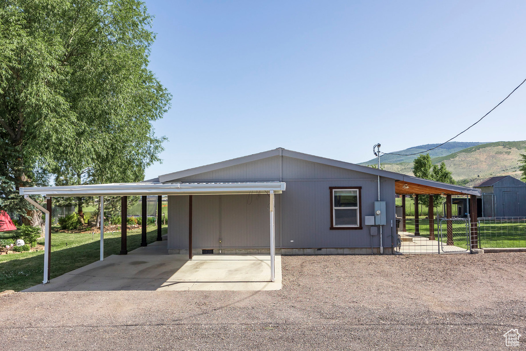 View of front of home with crawl space, a mountain view, and an attached carport