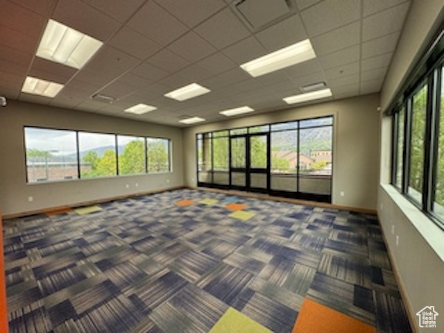 Carpeted spare room with healthy amount of natural light and a paneled ceiling