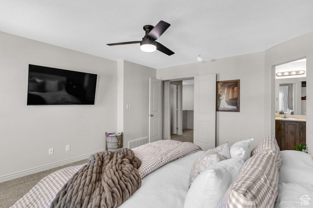 Carpeted bedroom with ceiling fan and ensuite bath