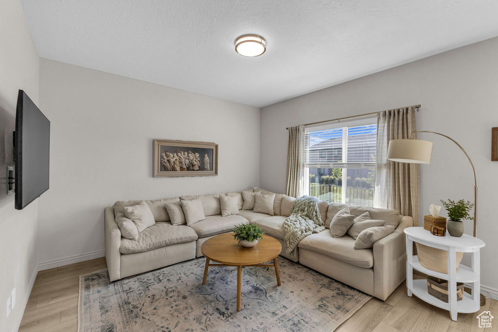Living area featuring light wood-style floors and baseboards