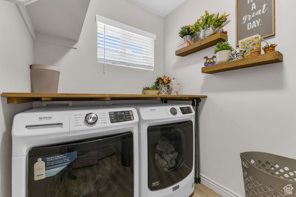 Laundry area with independent washer and dryer and wood finished floors