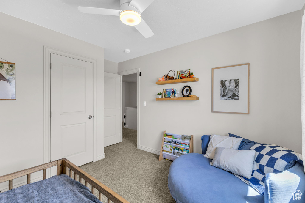 Carpeted bedroom featuring ceiling fan and baseboards