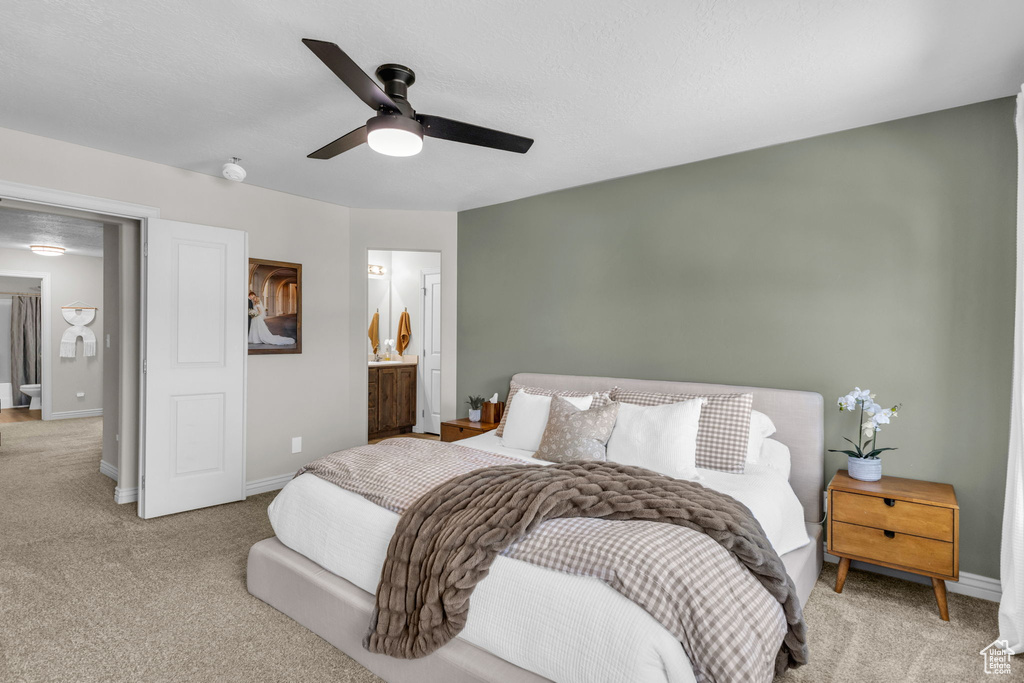 Bedroom with carpet, a ceiling fan, and connected bathroom