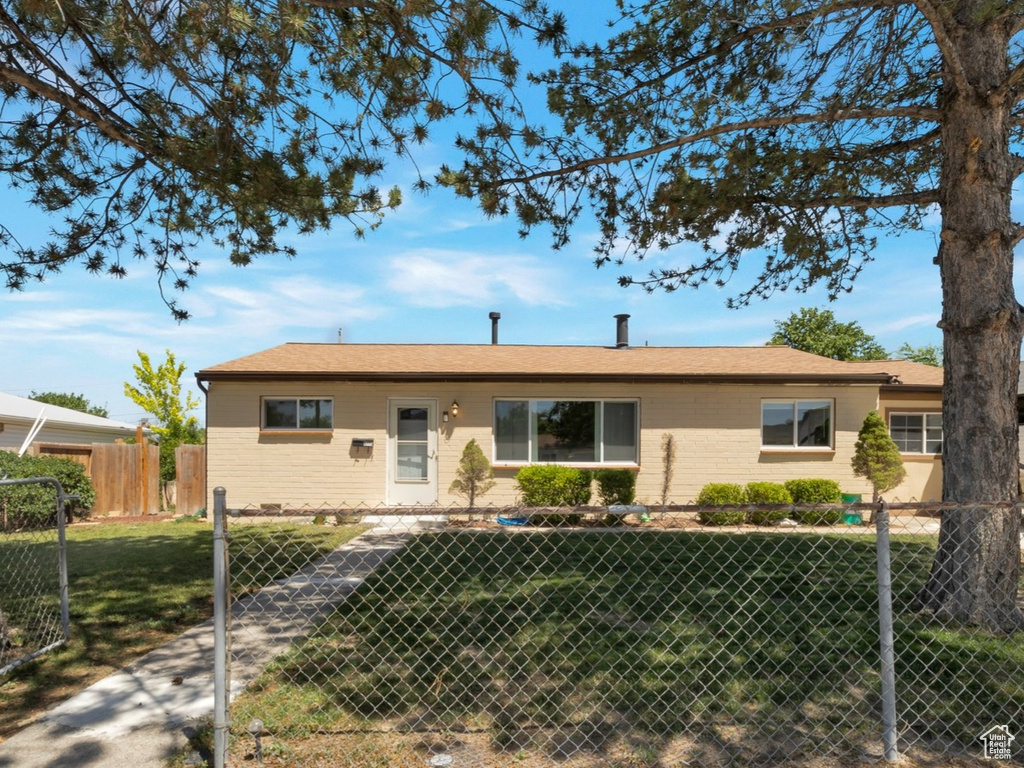 Ranch-style home featuring a fenced front yard and brick siding