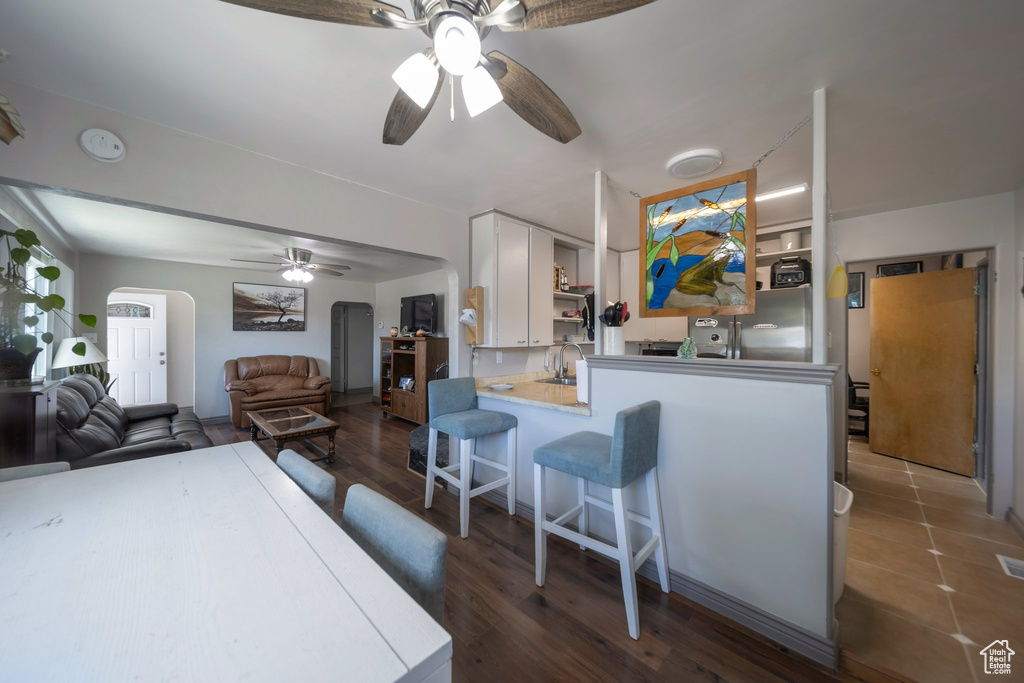 Playroom with a ceiling fan, arched walkways, and wood finished floors