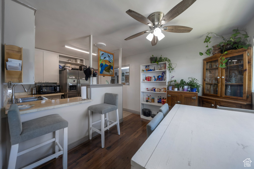 Dining room featuring dark wood-type flooring and ceiling fan