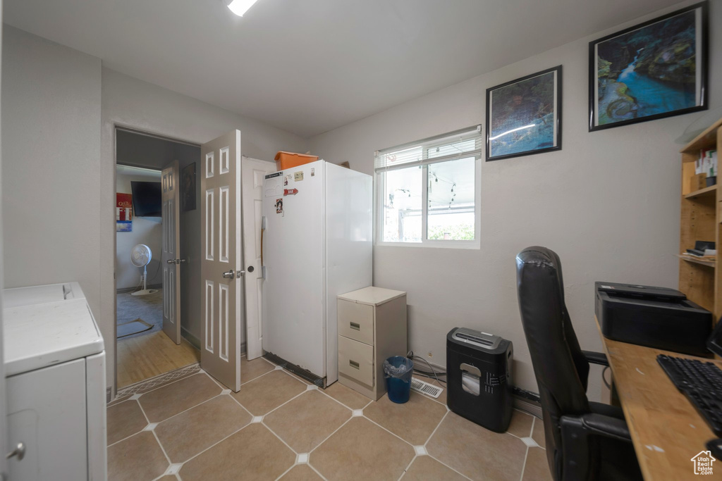 Office space with washer / dryer and light tile patterned floors