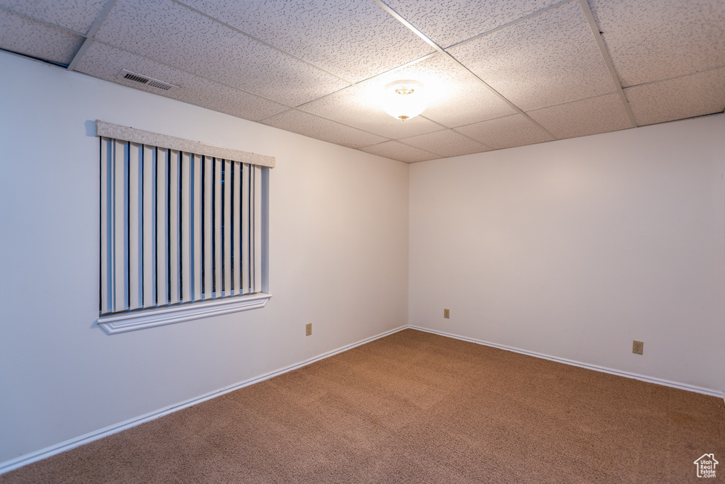 Spare room featuring a paneled ceiling and carpet flooring