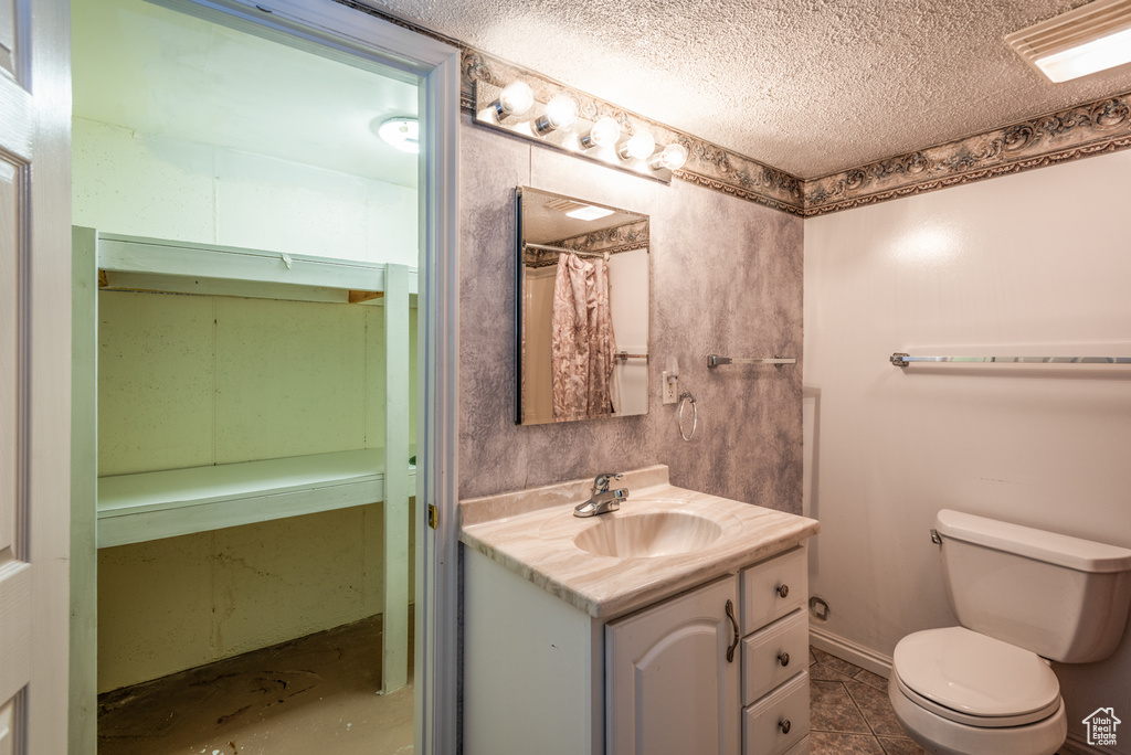 Bathroom featuring a textured ceiling, vanity, and tile patterned flooring