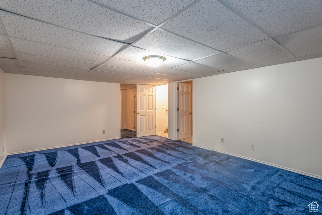 Finished below grade area featuring a paneled ceiling and carpet floors