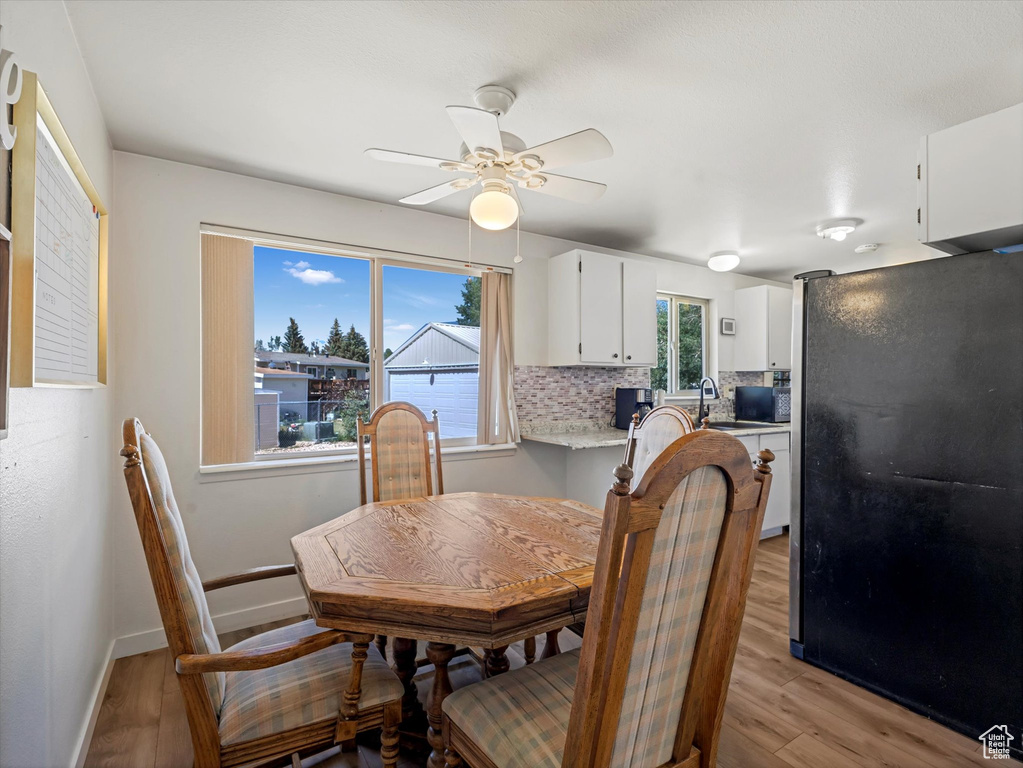 Dining space featuring light wood-type flooring and a ceiling fan