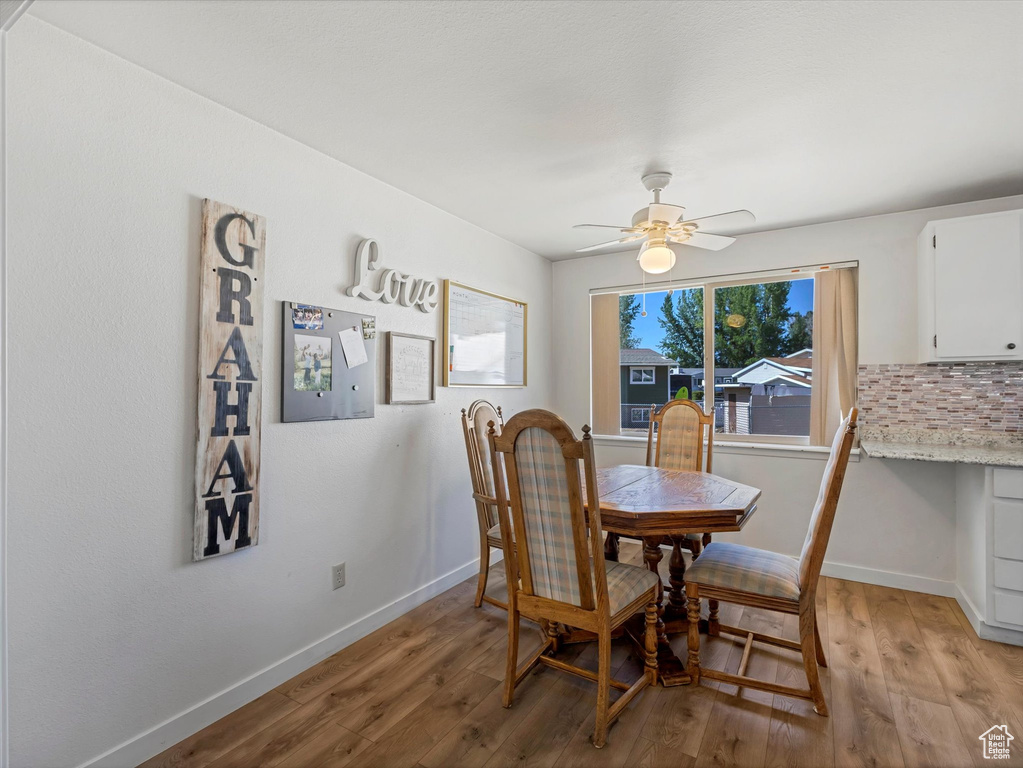 Dining area with light wood-style flooring and ceiling fan