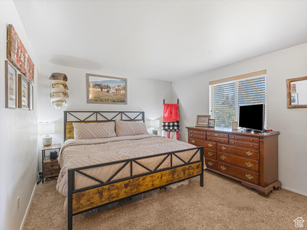 Bedroom featuring light carpet and baseboards