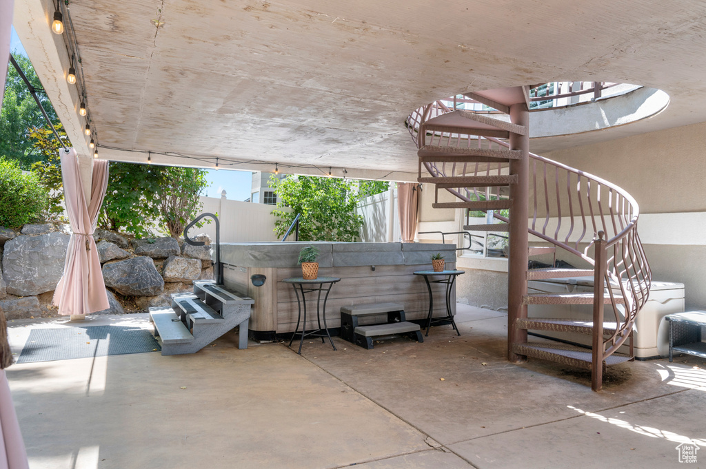View of patio / terrace with stairway and a hot tub