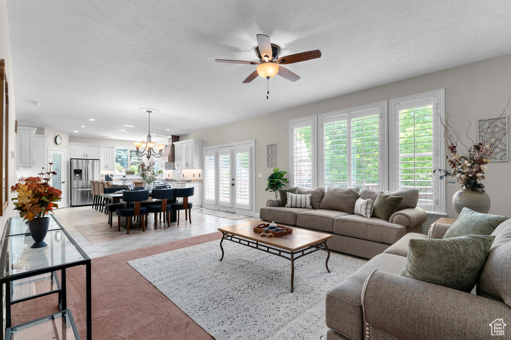 Living room with a ceiling fan, a chandelier, recessed lighting, and a textured ceiling