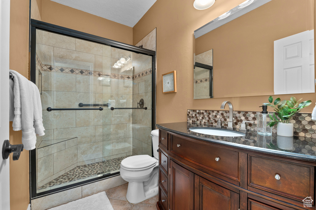 Bathroom featuring vanity, a stall shower, and tile patterned flooring