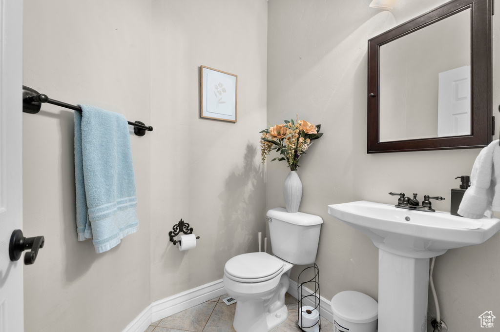 Half bath featuring toilet and tile patterned floors