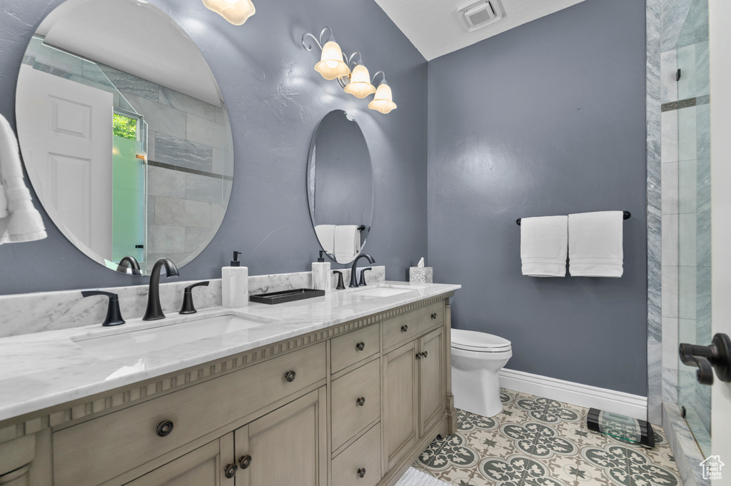 Bathroom featuring double vanity, a tile shower, and tile patterned floors
