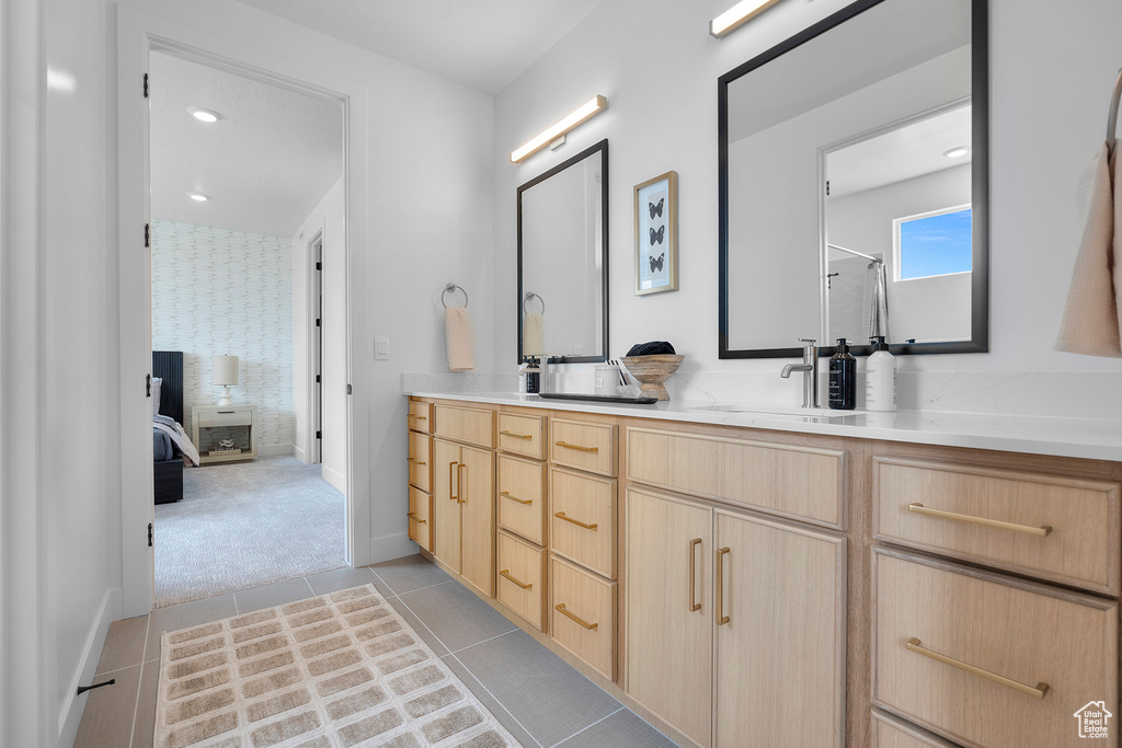 Ensuite bathroom featuring double vanity and tile patterned floors