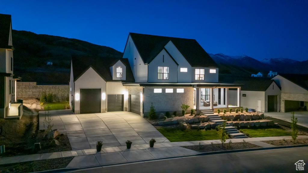 View of front of home featuring driveway, stucco siding, a garage, and a mountain view