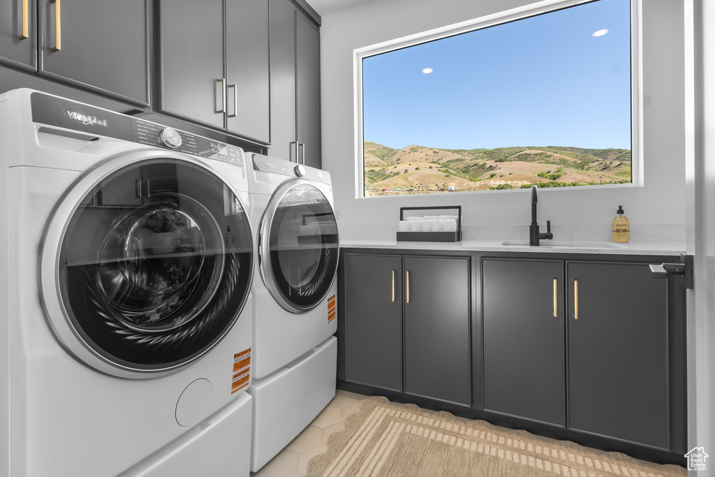 Laundry area featuring cabinet space, independent washer and dryer, and light tile patterned floors