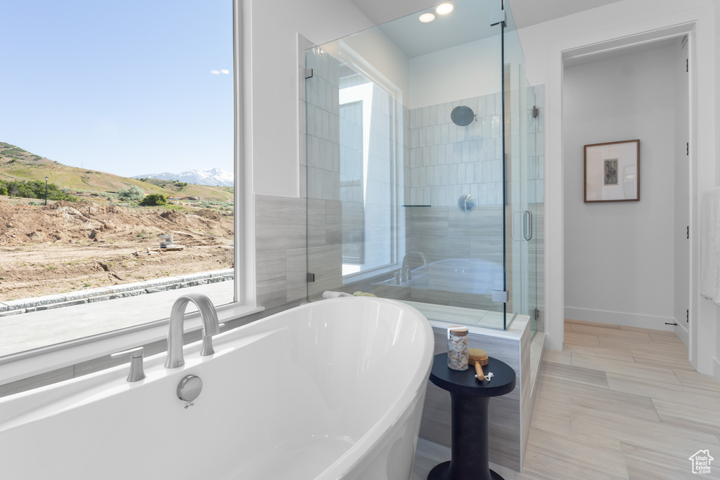 Full bath with a soaking tub, a stall shower, a mountain view, and recessed lighting