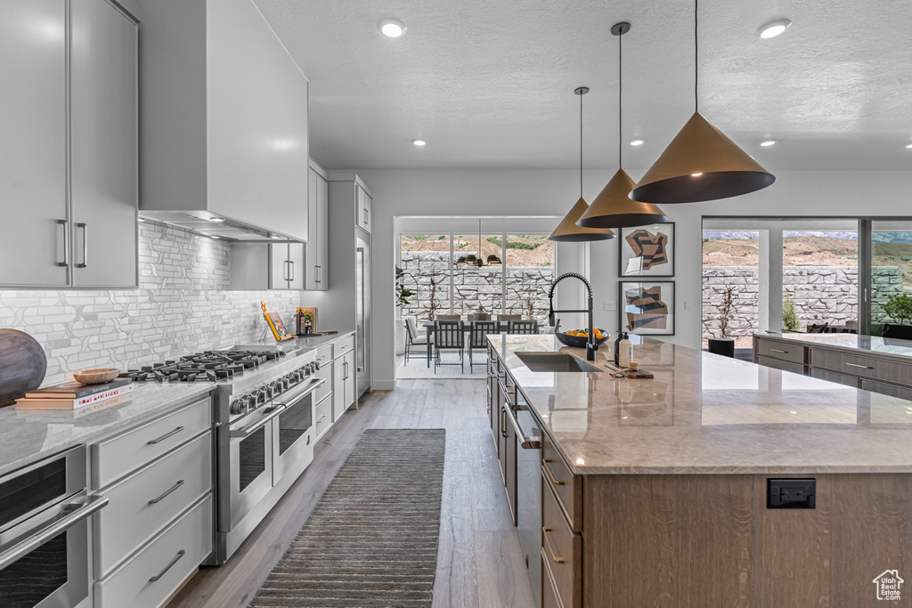 Kitchen featuring appliances with stainless steel finishes, a spacious island, healthy amount of natural light, tasteful backsplash, and recessed lighting