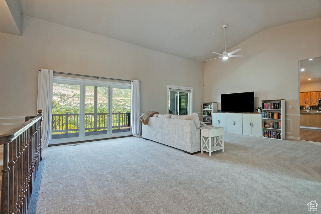Living room with carpet, high vaulted ceiling, and ceiling fan