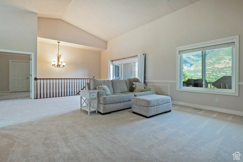 Living room featuring a chandelier, carpet, and high vaulted ceiling