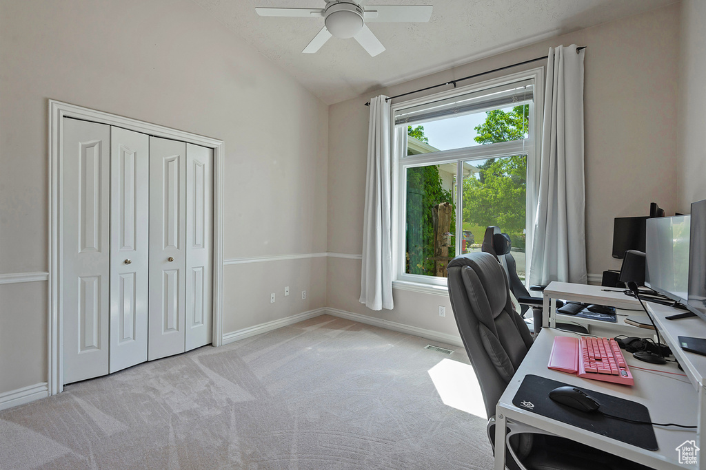 Home office featuring lofted ceiling, a ceiling fan, and light colored carpet