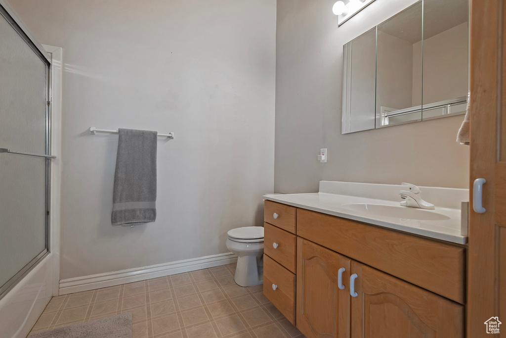 Full bathroom featuring vanity, tile patterned floors, and enclosed tub / shower combo