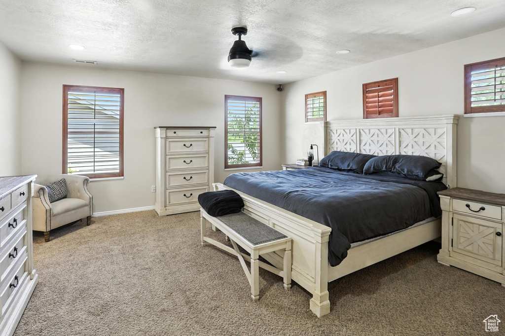 Bedroom with light colored carpet, recessed lighting, a textured ceiling, and a ceiling fan