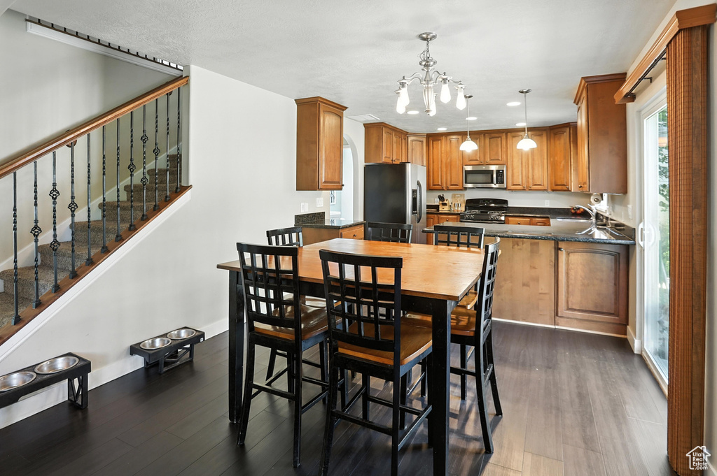 Dining room featuring a chandelier, dark wood-style floors, stairs, and recessed lighting