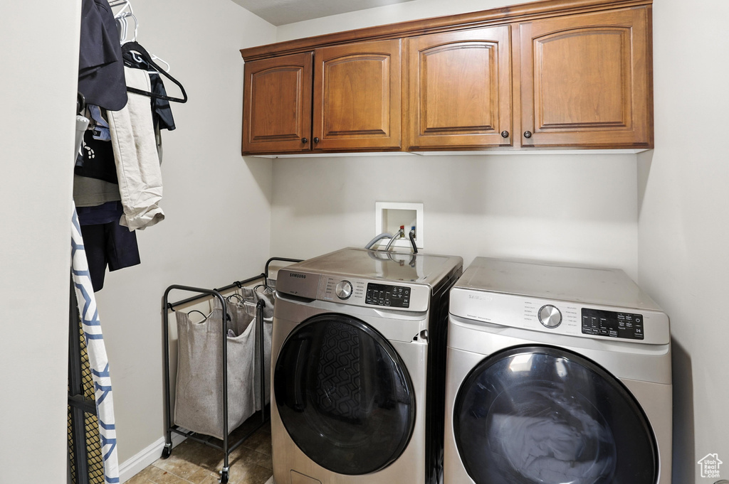 Washroom featuring independent washer and dryer and cabinet space