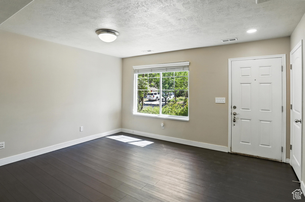 Foyer with a textured ceiling and dark wood-style flooring