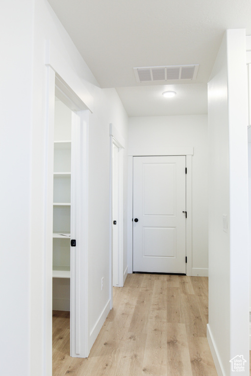 Corridor with light wood-style flooring
